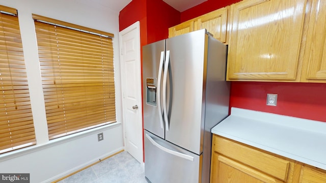 kitchen featuring stainless steel fridge with ice dispenser and light brown cabinetry