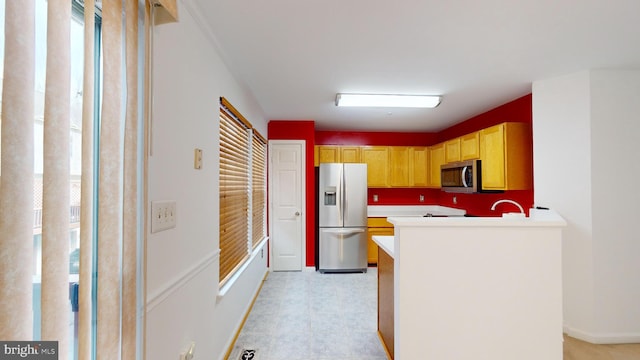 kitchen featuring kitchen peninsula, stainless steel appliances, and light brown cabinetry