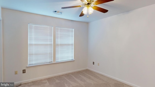 carpeted spare room featuring ceiling fan