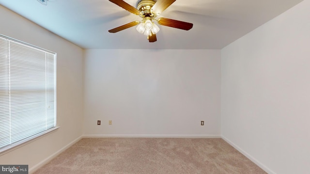 empty room featuring ceiling fan and light colored carpet