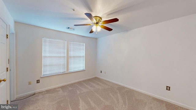 spare room with ceiling fan and light colored carpet