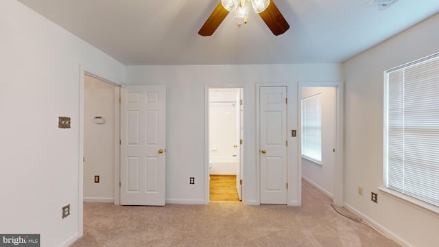 unfurnished bedroom with light carpet, ensuite bath, and ceiling fan