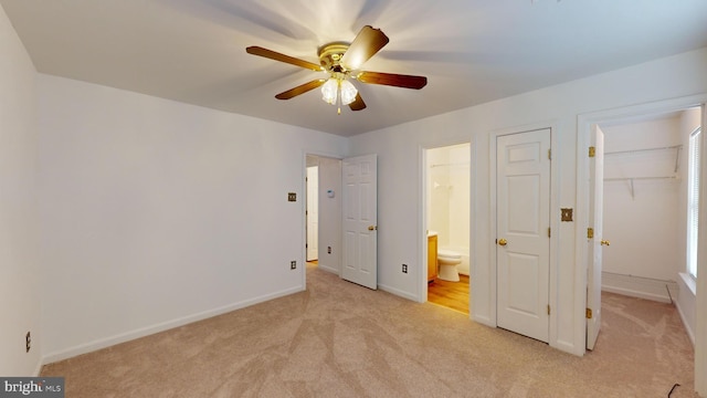 unfurnished bedroom featuring ensuite bathroom, ceiling fan, and light colored carpet