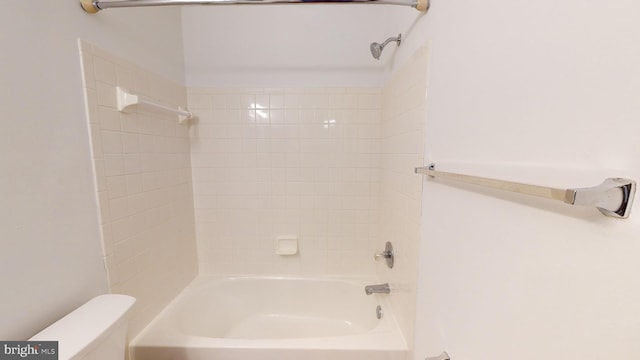 bathroom featuring toilet and tiled shower / bath