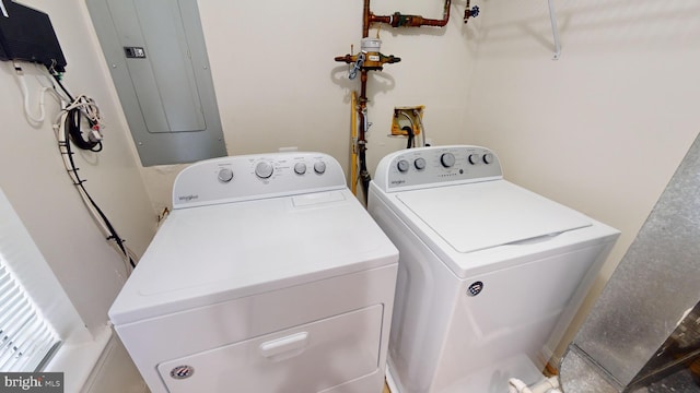 clothes washing area with washing machine and dryer and electric panel