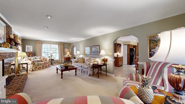 living room with ornamental molding, a fireplace, and light carpet