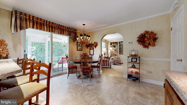 dining area with a notable chandelier, crown molding, and built in features