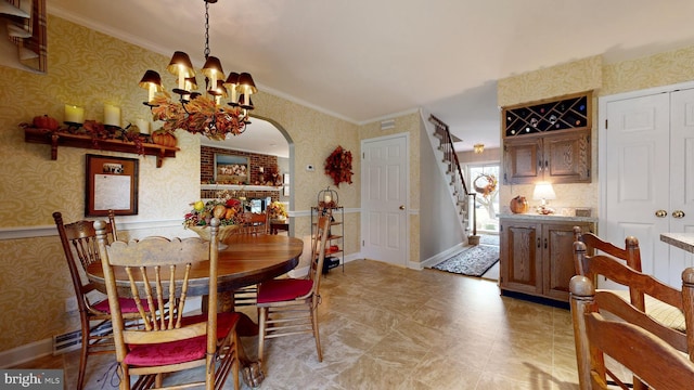 dining space with an inviting chandelier and ornamental molding