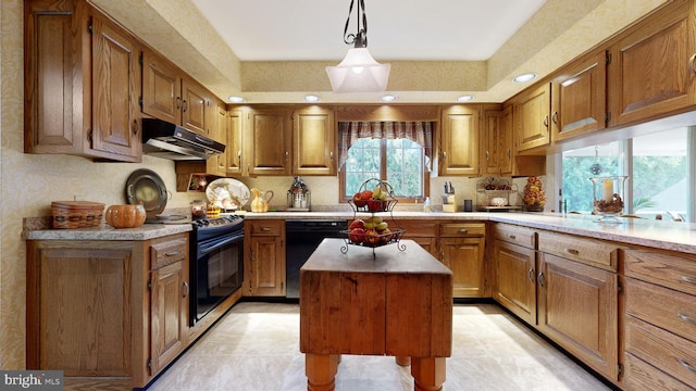 kitchen featuring a kitchen island, pendant lighting, sink, light tile patterned floors, and black appliances