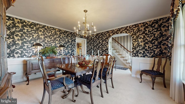 dining room with ornamental molding, carpet, and a chandelier