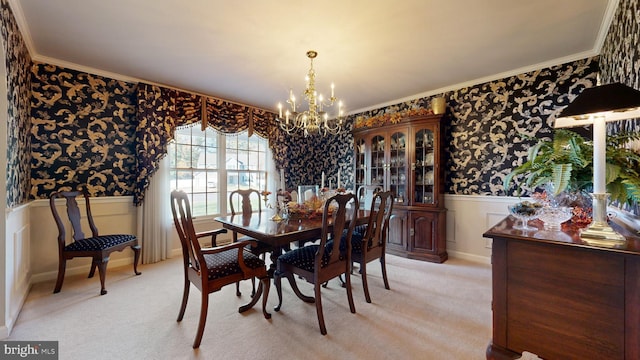 carpeted dining area with an inviting chandelier and ornamental molding