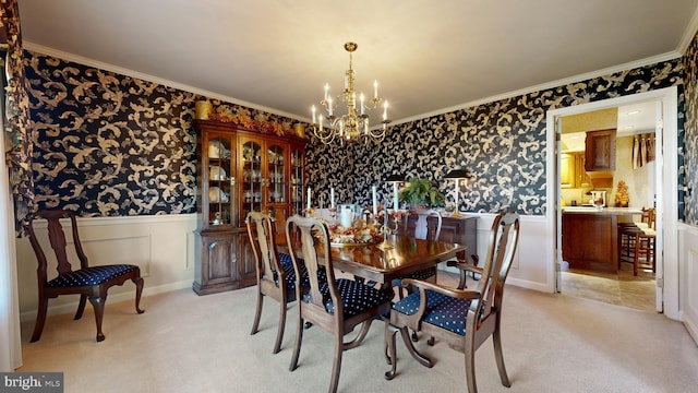 carpeted dining space with crown molding and a chandelier