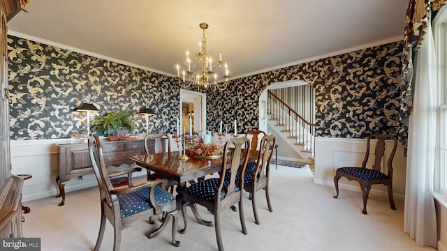 carpeted dining area featuring crown molding and a chandelier