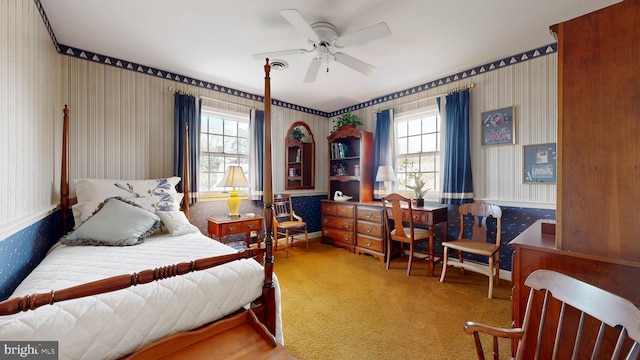 bedroom featuring multiple windows, light carpet, and ceiling fan