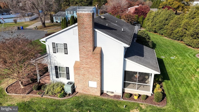 rear view of house featuring a yard and central air condition unit