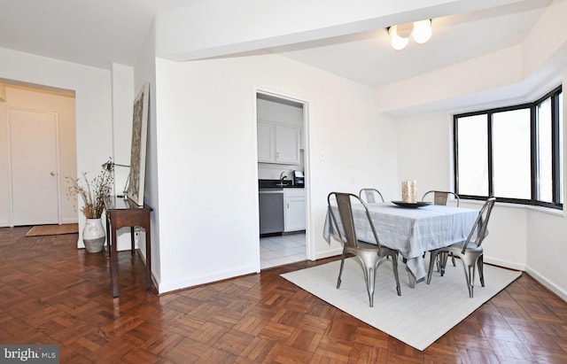 dining space featuring dark parquet flooring