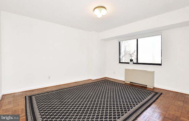 spare room with radiator and parquet flooring