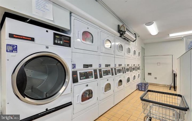 washroom featuring light tile patterned floors, stacked washer and clothes dryer, and washing machine and dryer