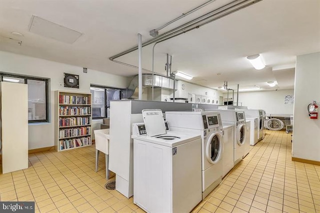 clothes washing area featuring light tile patterned flooring and independent washer and dryer