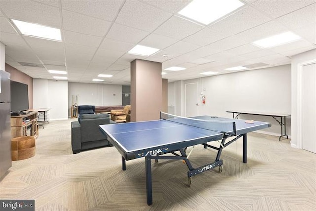 playroom with a paneled ceiling and light colored carpet