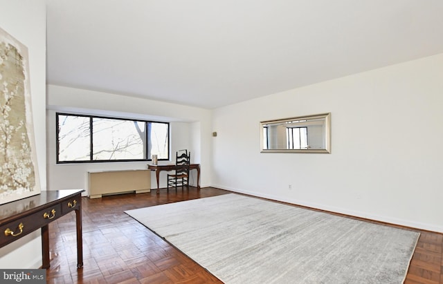 spare room featuring dark parquet floors and radiator