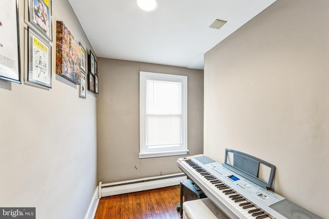 miscellaneous room featuring hardwood / wood-style flooring and a baseboard heating unit