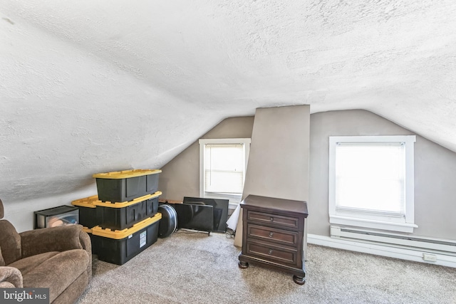 bonus room featuring vaulted ceiling, carpet flooring, a textured ceiling, and a baseboard heating unit