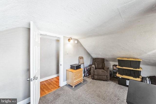 carpeted home office featuring a textured ceiling and lofted ceiling