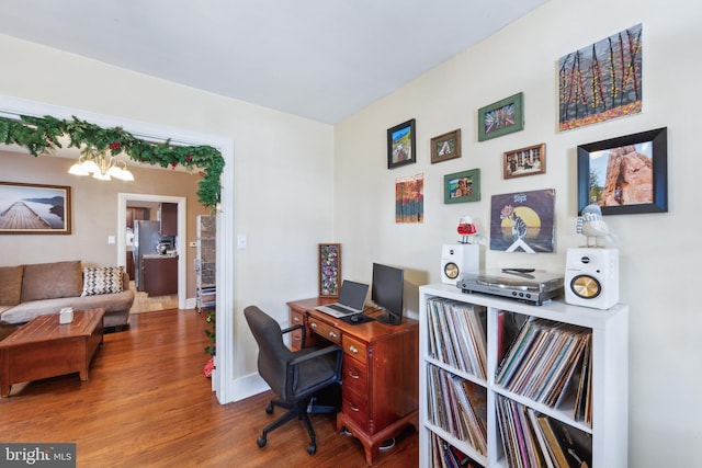 office area with hardwood / wood-style floors and a notable chandelier