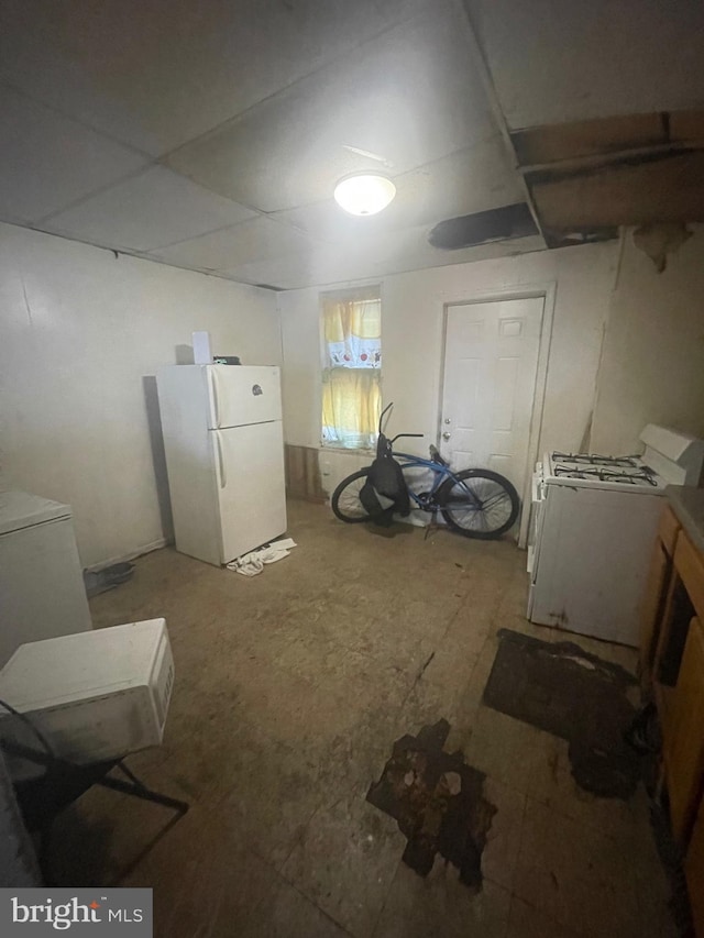 basement featuring washer / clothes dryer and white refrigerator