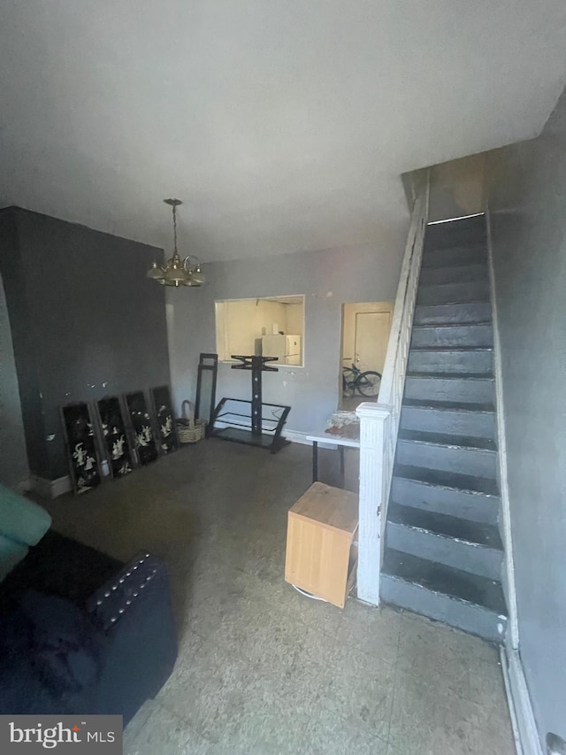 unfurnished living room featuring a chandelier