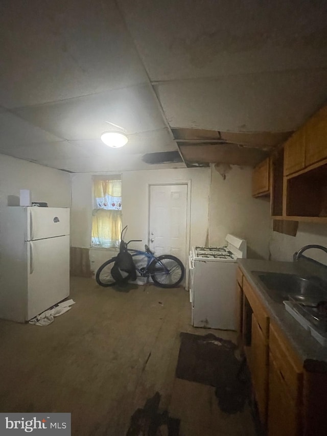 basement with washer / dryer, sink, and white refrigerator