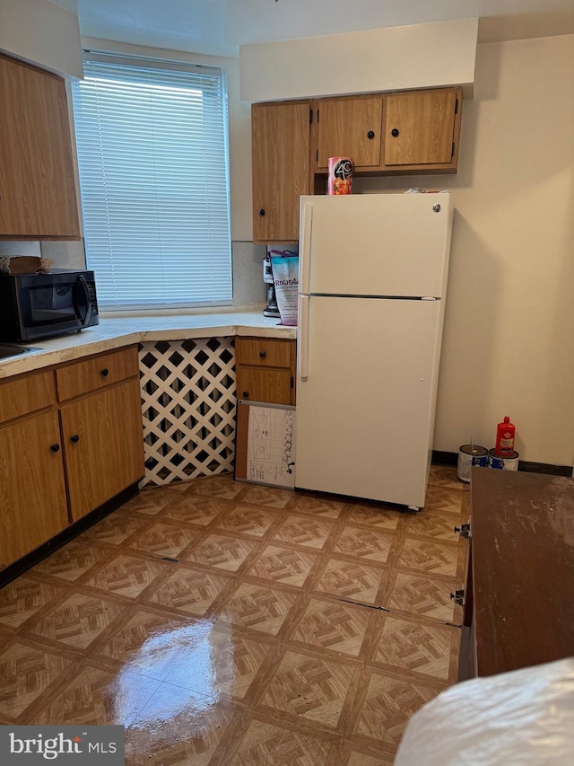 kitchen with white fridge and backsplash