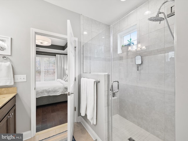 bathroom featuring hardwood / wood-style floors, vanity, a shower with shower door, and a wealth of natural light