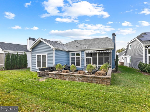 back of property featuring a sunroom and a lawn