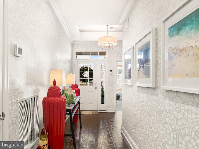 hallway featuring crown molding, dark hardwood / wood-style flooring, and an inviting chandelier