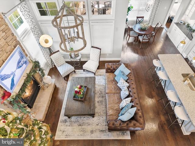 living room featuring a high ceiling, dark hardwood / wood-style flooring, and a notable chandelier