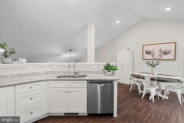 kitchen with stainless steel dishwasher, vaulted ceiling, dark wood-type flooring, sink, and white cabinetry