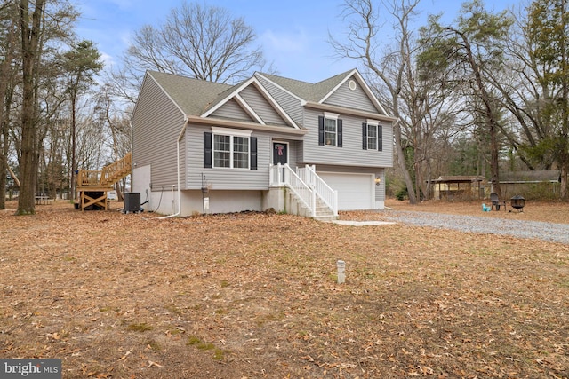 split foyer home with a garage and central AC unit