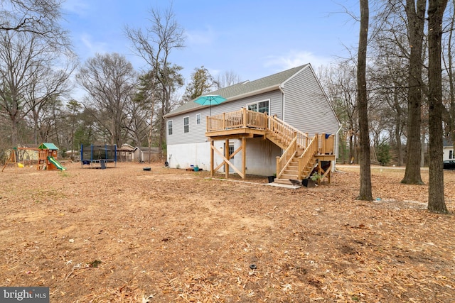 rear view of house with a playground, a trampoline, and a deck