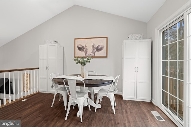 dining space with dark hardwood / wood-style flooring and vaulted ceiling