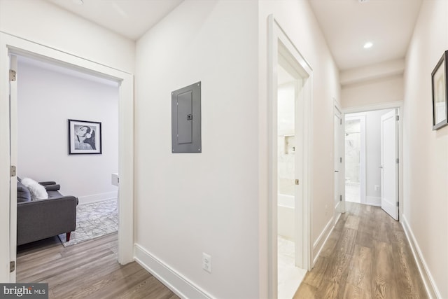 corridor with electric panel and hardwood / wood-style floors