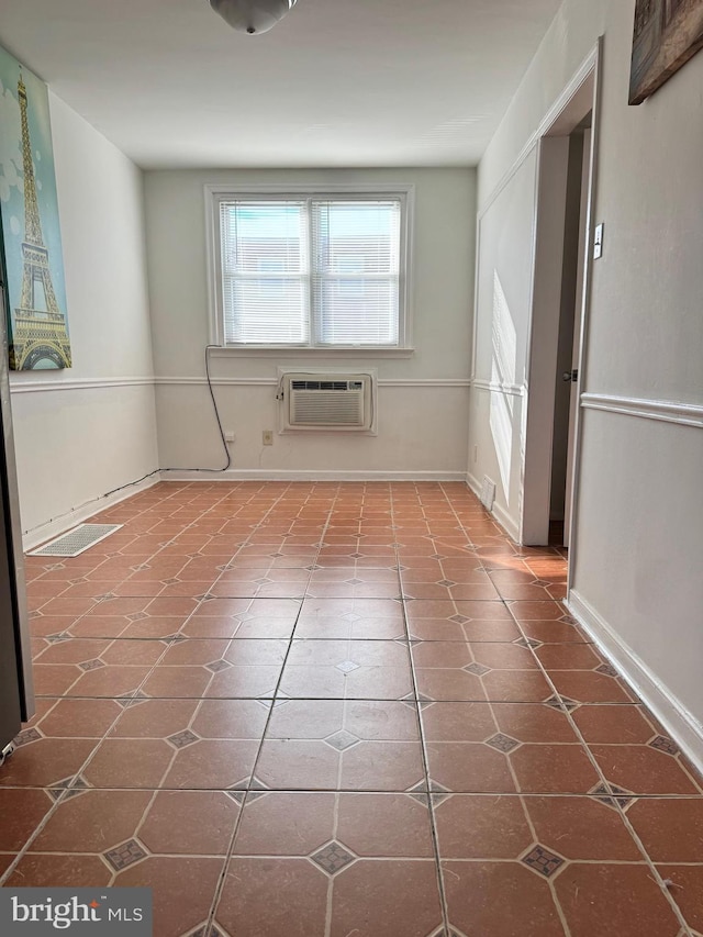 unfurnished room featuring tile patterned floors and a wall unit AC