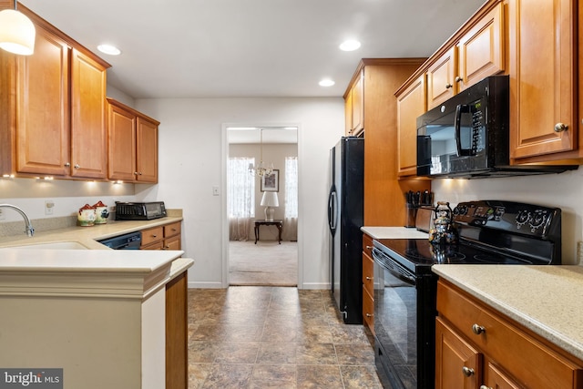 kitchen featuring recessed lighting, light countertops, a sink, and black appliances