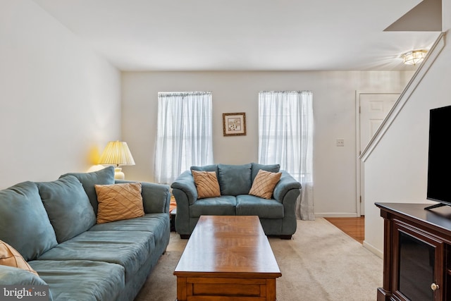 living room featuring light carpet and baseboards