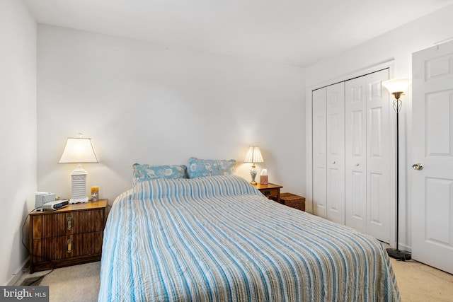 carpeted bedroom featuring a closet and baseboards