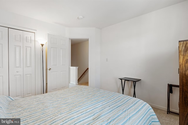 bedroom with light carpet and a closet