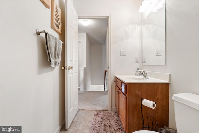 half bath featuring tile patterned flooring, baseboards, vanity, and toilet