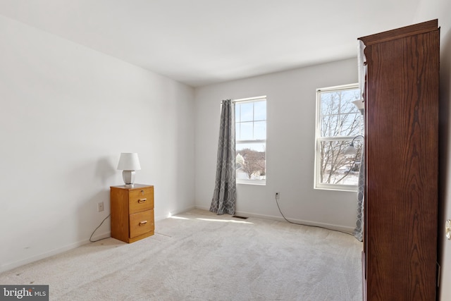 unfurnished bedroom with light colored carpet, visible vents, and baseboards