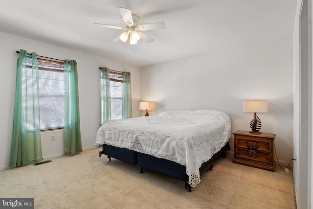 bedroom featuring ceiling fan, carpet floors, visible vents, and baseboards